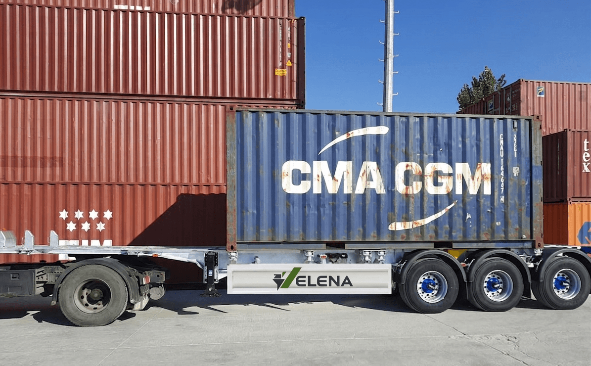Blue CMA CGM container on a white ELENA trailer before stacked red shipping containers.